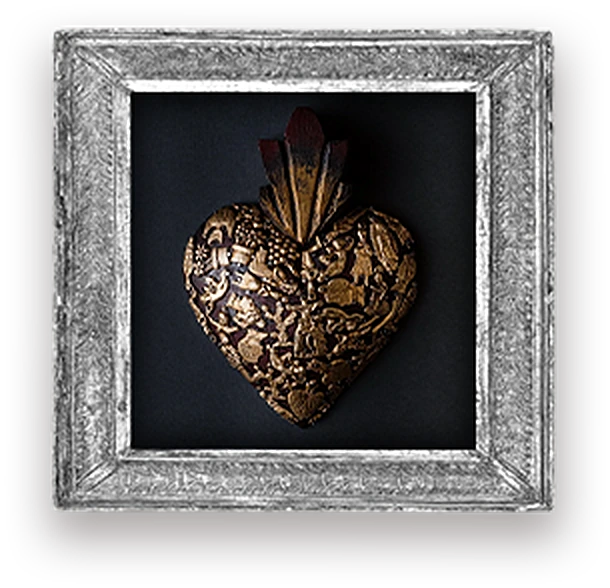 A carved gold sacred heart, in a pressed-tin frame